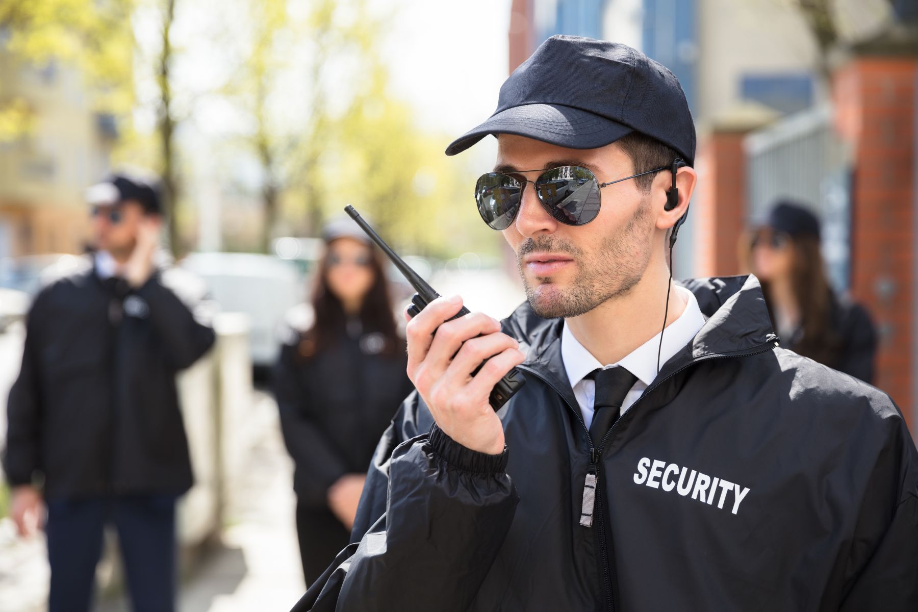 Equipo de seguridad privada de élite de Armarium coordinando operaciones tácticas con radiocomunicación frente a un corporativo.